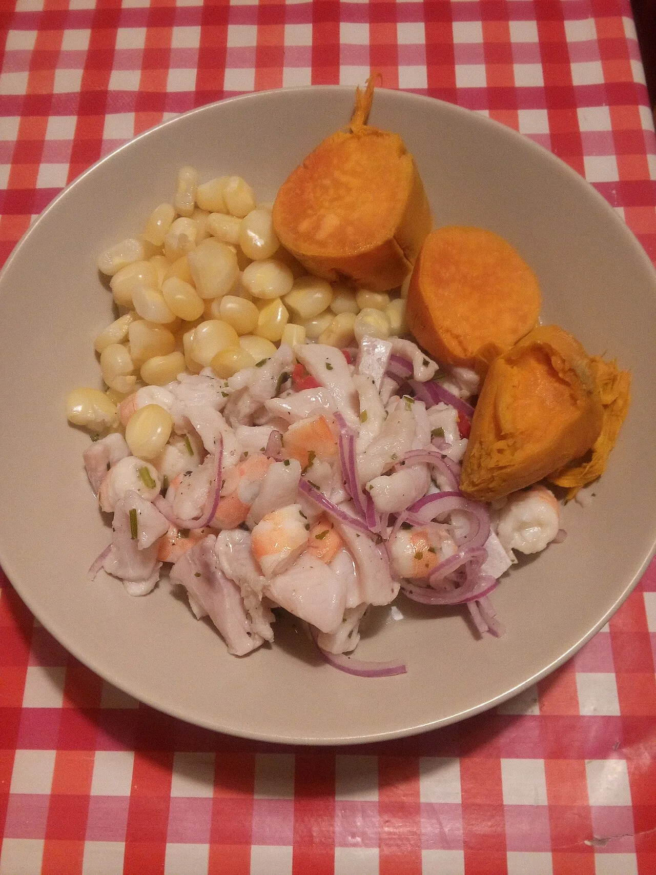 Перуанское севиче: кубики белой рыбы с красным луком, рядом варёная кукуруза чокло и батат
